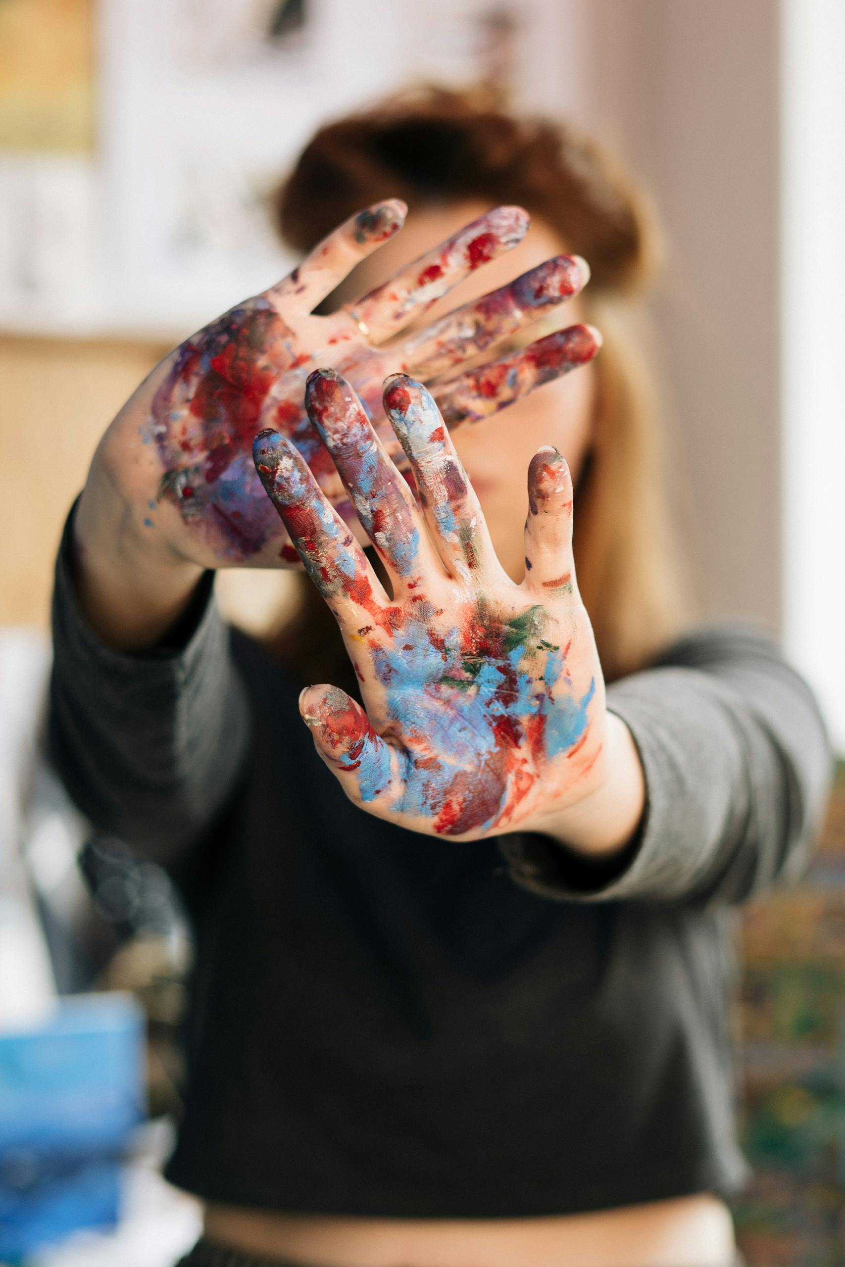 Close-up of hands with colorful paint, showing artistic expression.